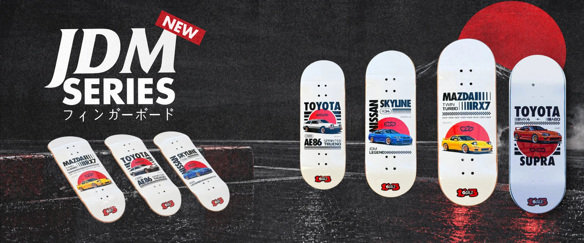 Serie JDM de Galo Fingerboard: cuatro decks blancos con autos japoneses y sol rojo sobre una pista nocturna