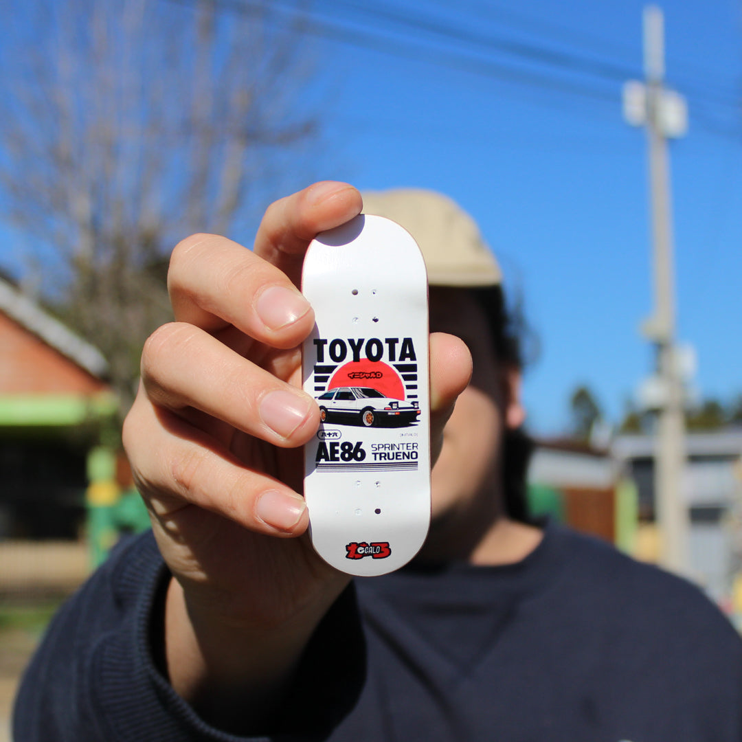 Mano sosteniendo el deck fingerboard Galo JDM Trueno al aire libre