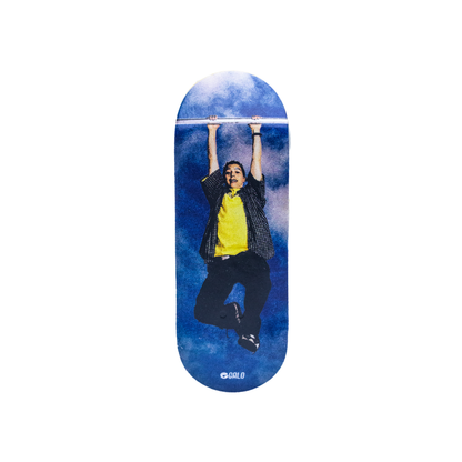Deck fingerboard Galo Serie Malcolm Reese, ilustración de Reese colgando de una barra sobre cielo azul